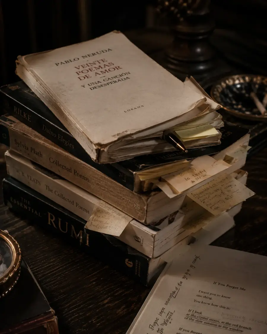 A translator's desk covered with worn poetry books, handwritten notes, and unfinished pages